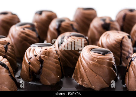 Pezzi di bomboni ricoperti di cioccolato fuso sullo sfondo Foto Stock