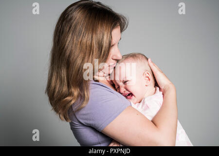 Madre cercando di calmare il suo pianto baby Foto Stock