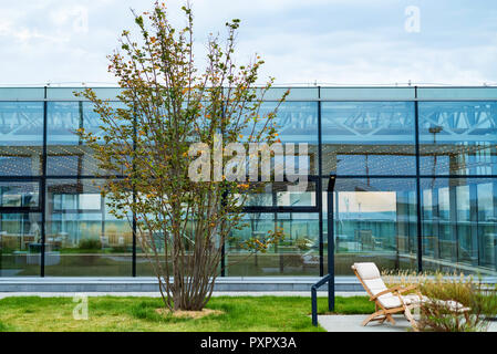 Moderno patio sul tetto con poltrona in legno durante il giorno Foto Stock