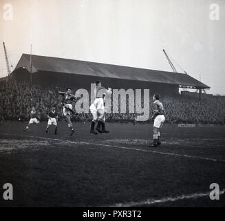 Degli anni Cinquanta, storico, una partita di calcio al vecchio Den, New Cross, London SE14, la casa del Millwall FC, fondata nel 1885. La grande massa che ha aperto nel 1910 e mentre è in uso era noto come 'l'Den', potrebbe assumere 47.000 spettatori, con oltre 43.000 di questi in piedi. Il cavalletto principale piena di spettatori può essere visto nella foto. Foto Stock