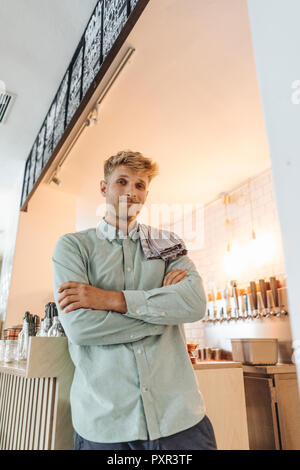 Giovane uomo che lavora nella sua start-up cafe, ritratto Foto Stock