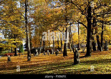 Il vecchio cimitero con antiche lapidi e colori autunnali Foto Stock