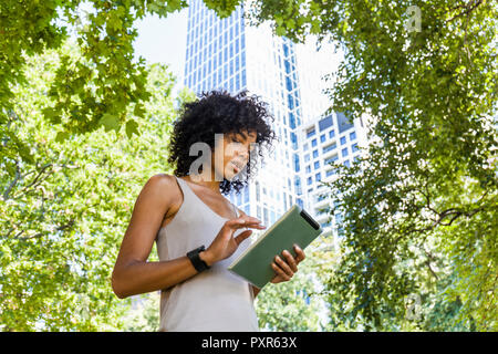 Germania, Francoforte, giovane donna utilizzando tablet in città Foto Stock