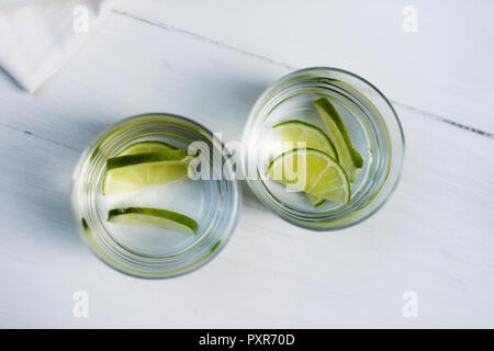 Due bicchieri di acqua con spicchi di lime Foto Stock
