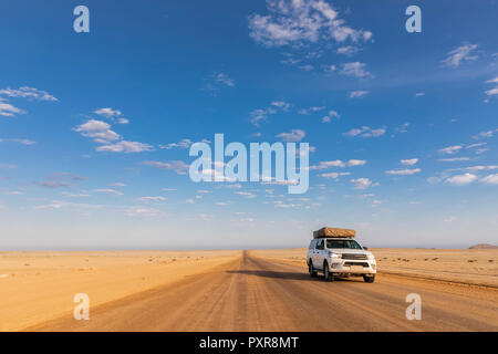 In Africa, la Namibia, il deserto del Namib Naukluft, Parco Nazionale, veicolo fuoristrada su strada di ghiaia Foto Stock