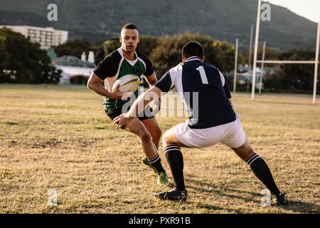 giocatori di rugby che corrono con palla e placcano durante la partita. giocatori di rugby che lottano per la palla nella partita. Foto Stock