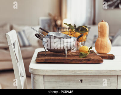 Nostalgiche di utensili da cucina e di frutti sul vecchio tavolo in legno Foto Stock