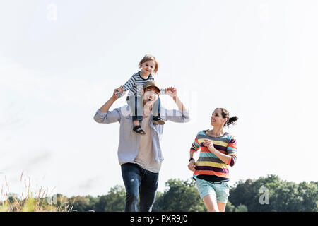 La famiglia felice passeggiate in riva al fiume e su un bel giorno di estate Foto Stock