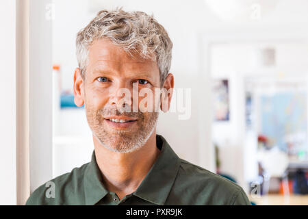 Ritratto di sorridere uomo maturo con i capelli grigi e di stoppie a casa Foto Stock