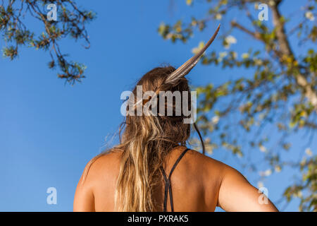 Donna con piume nei capelli Foto Stock