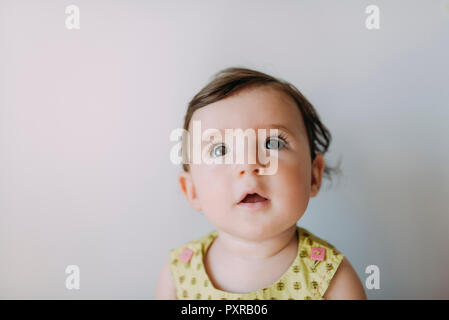 Sorpreso bambina cercando su sfondo bianco Foto Stock