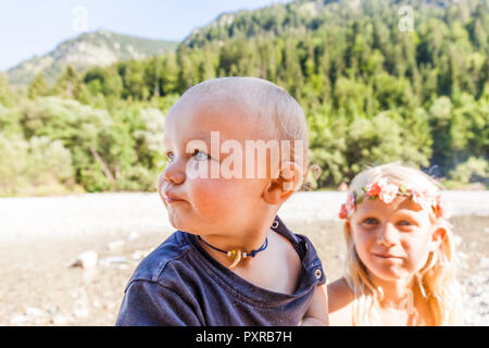 Ritratto di bambino e bambina indossa corona di fiori all'aperto in estate Foto Stock