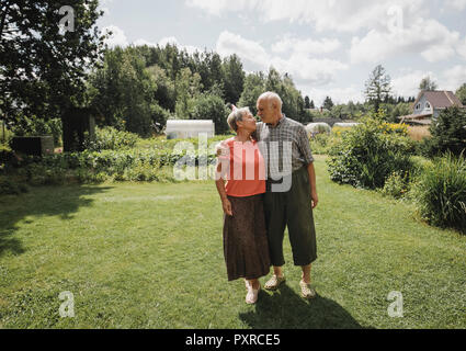 Felice coppia senior in piedi in giardino Foto Stock