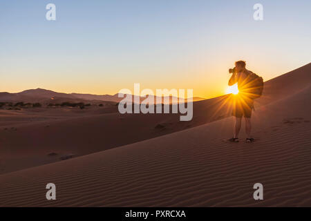 In Africa, la Namibia, il deserto del Namib Naukluft, Parco Nazionale, fotografo su dune durante il sunrise Foto Stock