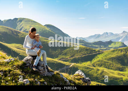 In Germania, in Baviera, Oberstdorf, madre e figlia piccola su una escursione in montagna avente una pausa Foto Stock