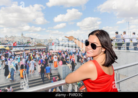 Bella donna cinese mostra Torre Galata al quartiere Eminonu a Istanbul, Turchia Foto Stock