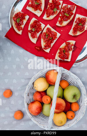 La bruschetta e frutta fresca sulla coperta picnic Foto Stock