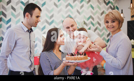 Cena in famiglia. Famiglia riceve gli ospiti, un incontro festoso. family serve la tabella e comunica con l'altra. I genitori i figli e i nipoti in Foto Stock