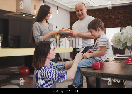 Cena in famiglia. Famiglia riceve gli ospiti, un incontro festoso. family serve la tabella e comunica con l'altra. I genitori i figli e i nipoti in Foto Stock