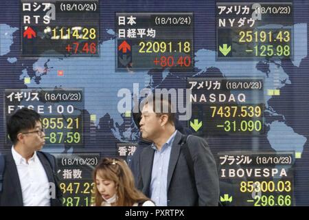 Tokyo, Giappone. 24 ott 2018. I pedoni a piedi passato un magazzino elettronico di bordo che mostra in Giappone il Nikkei stock medio in Tokyo. Il Nikkei 225 Stock rose media 80.40 punti o 0,37 percento a 22,091.18 mercoledì come un risultato di mercati cinesi recuperato. Credito: Rodrigo Reyes Marin/ZUMA filo/Alamy Live News Foto Stock