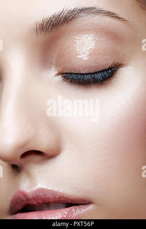 Macro Closeup colpo di volto femminile e gli occhi la bellezza del trucco. Donna con glitter lucida di pelle bianca. Foto Stock