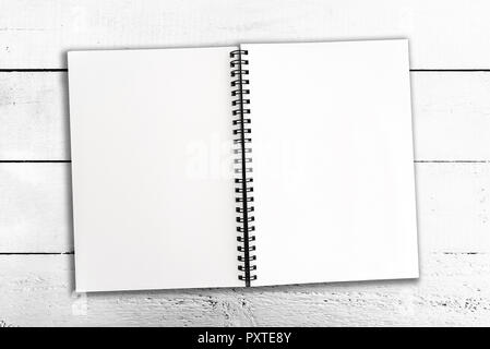 Aperto a spirale vuota notepad su bianco tavola in legno rustico Foto Stock