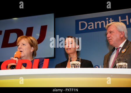 Dieburg, Germania. 23 Ott, 2018. Angela Merkel, il cancelliere della Germania, Caroline Bosbach e Volker Bouffier, il Ministro Presidente dello Stato tedesco di Hesse, sono raffigurati al comizio elettorale da sinistra a destra. Il cancelliere tedesco Angela Merkel ha partecipato a una manifestazione politica del suo partito CDU in Dieburg in vista delle prossime elezioni statali dello stato tedesco di Hesse. Con meno di una settimana per andare alle elezioni, il CDU è ancora leader i sondaggi, ma il gas ha perso più del 10% rispetto alle ultime elezioni. Credito: Michael Debets/Pacific Press/Alamy Live News Foto Stock