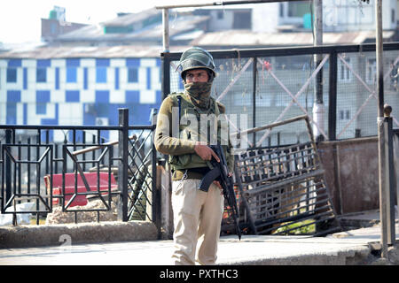 Srinagar, India. 23 Ott, 2018. Poliziotto indiano si erge alert durante il coprifuoco a Srinagar, Indiano Kashmir amministrato il 23 ottobre 2018. Le autorità avevano collocato il coprifuoco nella città di Srinagar e bloccate tutte le strade che portano al centro della città al fine di contrastare i possibili manifestazioni di protesta che era stato chiamato da pro-libertà leader sui recenti massacri civili. Credito: Muzamil Mattoo/Pacific Press/Alamy Live News Foto Stock