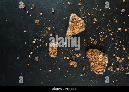 Tre pezzi di massa di cioccolato su sfondo nero con copia spazio, laici piatta Foto Stock