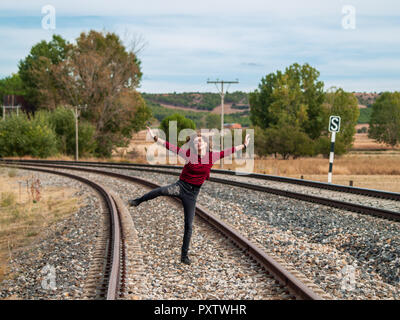 Una ragazza adolescente di saltare sul treno. Concetto di libertà e di gioia Foto Stock