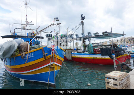 Vivacemente colorati di lavoro tradizionali barche da pesca attrezzate per la pesca di notte nel porto di Marsaxlokk, Malta Foto Stock