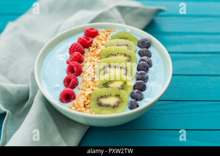 Ciotola frullato con mirtilli, lamponi, kiwi e nocciole tritate Foto Stock