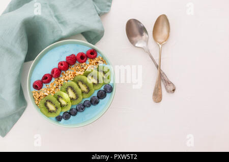 Ciotola frullato con mirtilli, lamponi, kiwi e nocciole tritate Foto Stock