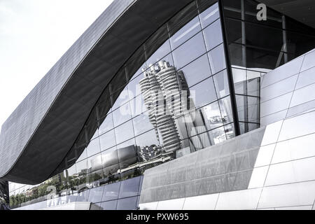 BMW Firmenzentrale spiegelt sich in der Glasfassade der BMW-Welt, München, Bayern, Deutschland, Europa Foto Stock