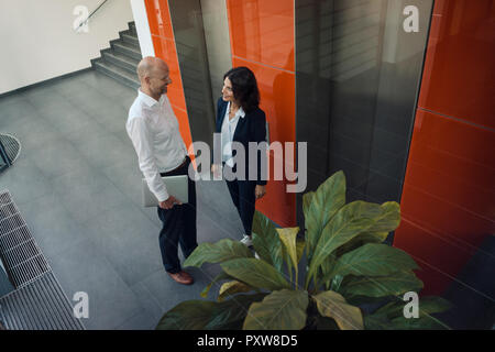 La gente di affari di parlare di fronte ascensore Foto Stock