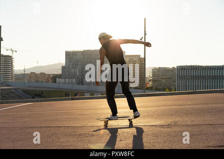 Giovane uomo che cavalca skateboard in città Foto Stock