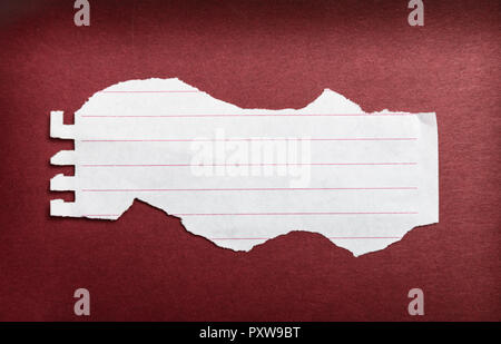 Girare la carta per notebook on dark sfondo rosso Foto Stock