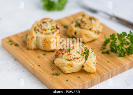 Le ciambelle glassate con feta, crema di formaggio, pancetta e prezzemolo sulla tavola di legno Foto Stock