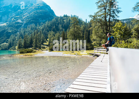 Austria, Tirolo, escursionista presso il lago Seebensee seduto sul lungomare, prendendo una pausa Foto Stock