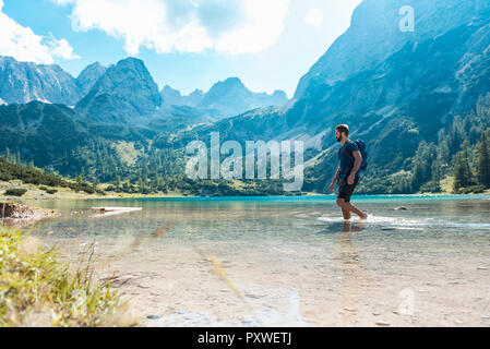 Austria, Tirolo, escursionista presso il lago Seebensee a piedi profondo della caviglia in acqua Foto Stock
