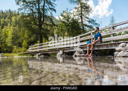 Austria, Tirolo, escursionista presso il lago Seebensee seduto sul lungomare, prendendo una pausa Foto Stock