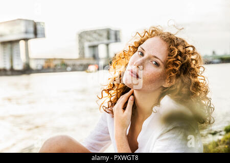 Germania, Colonia, ritratto di freckled giovane donna con ricci capelli rossi Foto Stock