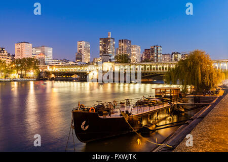 Francia, Parigi, Pont de Bir-Hakeim, Senna, alti edifici moderni a blue ora Foto Stock