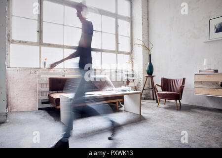 Donna che cammina in un loft Foto Stock