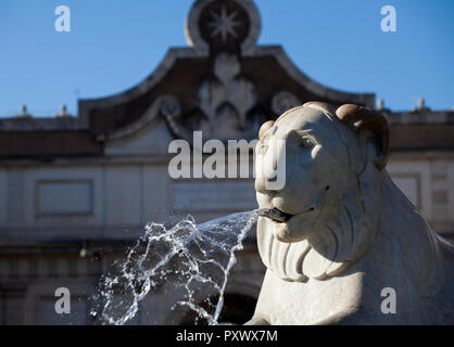 Dettaglio della Fontana dei Lions in Piazza del Popolo a Roma con la vecchia porta della città all'entrata nord di Roma dietro il leone scolpito. Foto Stock