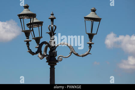 Uno dei molti lampioni decorativi che possono essere trovati nella città di Roma. Si è delineato contro un cielo blu. Foto Stock