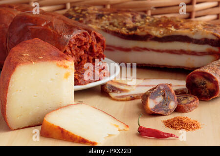 Varietà di prodotti contenenti peperoncino prodotto in Calabria, Italia meridionale, su legno e paglia tessuta sfondo. Foto Stock