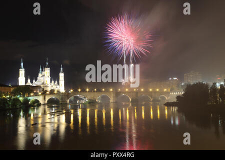 I fuochi d'artificio durante il 2018 Pilar festival accanto alla Cattedrale del Pilar e il ponte di pietra sul fiume Ebro, a Saragozza, regione di Aragona, Spagna Foto Stock