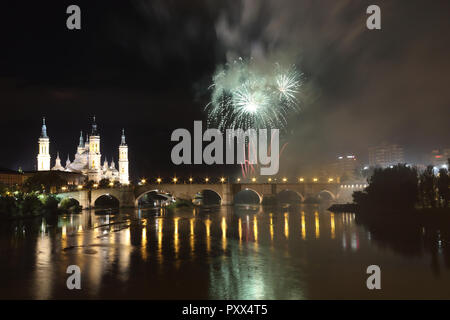 I fuochi d'artificio durante il 2018 Pilar festival accanto alla Cattedrale del Pilar e il ponte di pietra sul fiume Ebro, a Saragozza, regione di Aragona, Spagna Foto Stock
