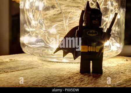 Una vita ancora in composizione con LEGO Batman, un vasetto di vetro con un coperchio in pelle riempita con una corda di canapa e alcuni luminosi led luminoso su un ruvido legno Foto Stock